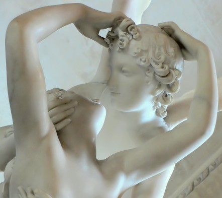 A statue of a man and woman kissing in while marble.