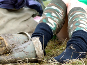 Legs with green muddy wellies and camo socks